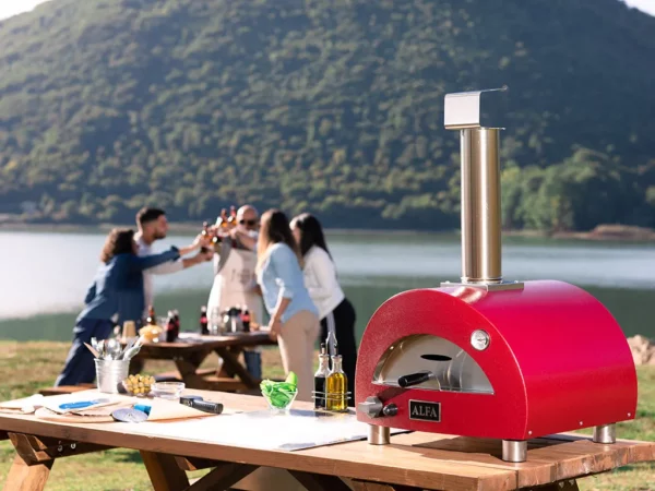 alfa moderno portable pizza oven four à pizza antique red people in background baking pizza outdoors